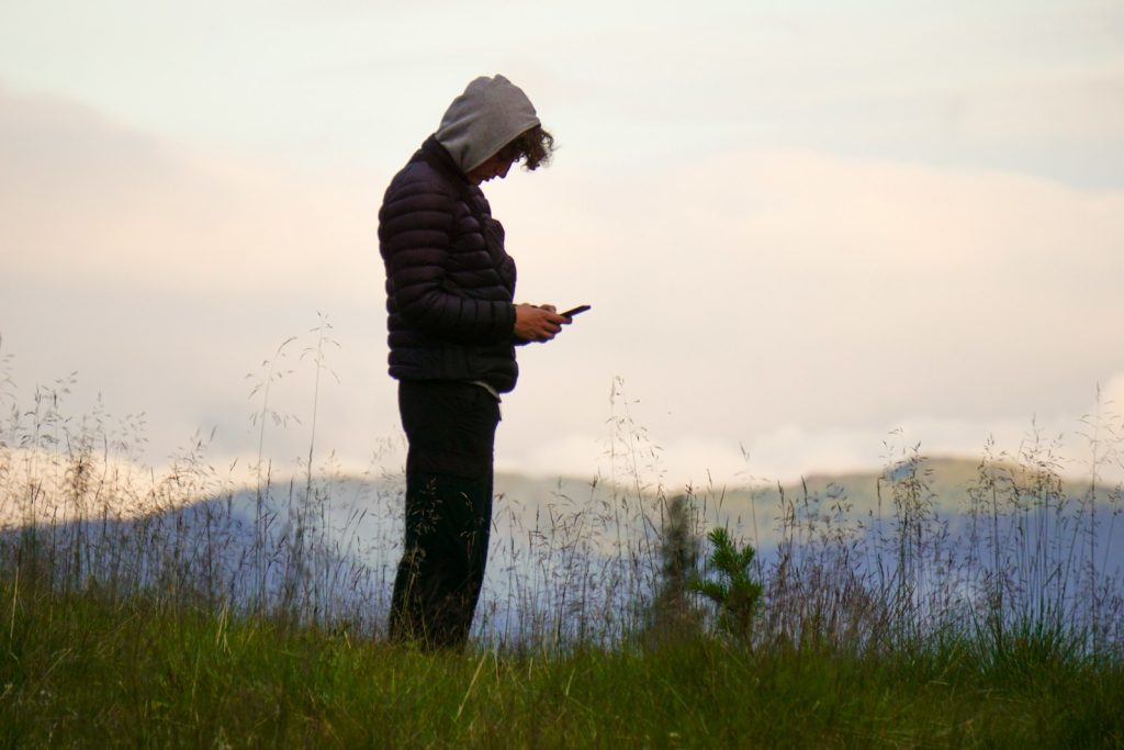 man in black jacket standing on green grass field during daytime