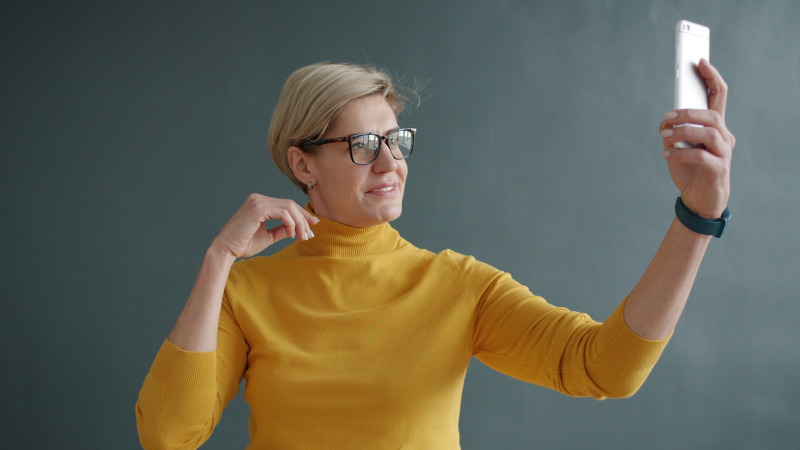 Woman in yellow turtleneck taking a selfie